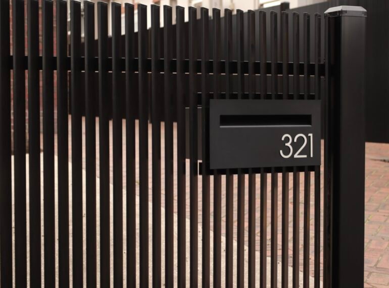 Architectural aluminium vertical angled blade fence with Milkcan letterbox
