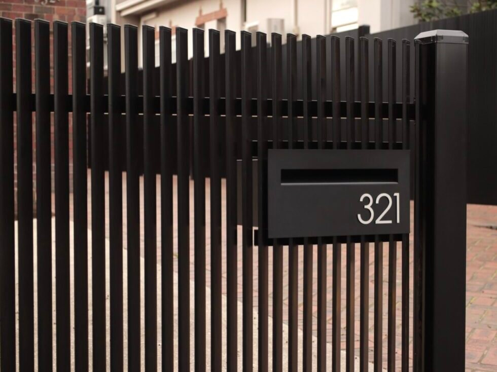 Architectural aluminium vertical angled blade fence with Milkcan letterbox scaled e1785212589648